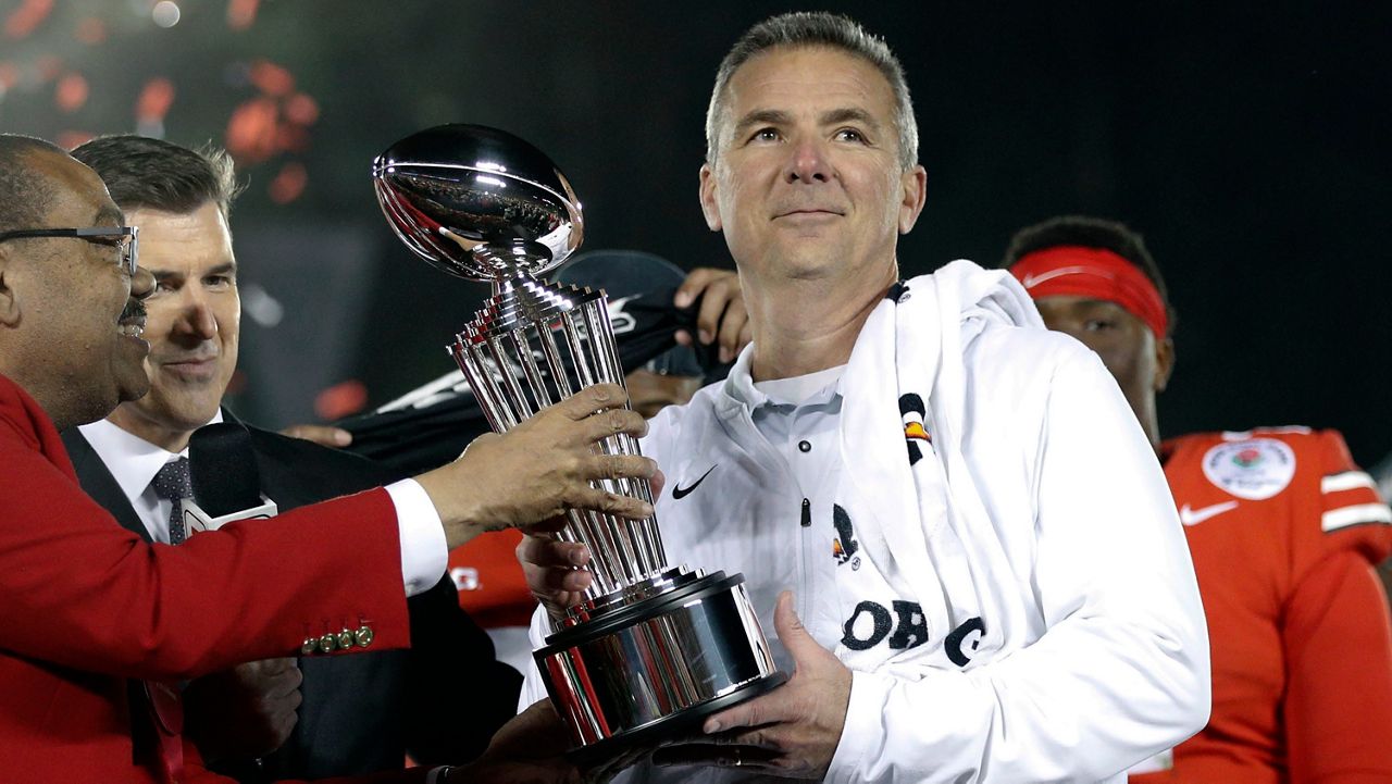 Ohio State coach Urban Meyer, right, holds the trophy after the team's 28-23 win over Washington in the Rose Bowl NCAA college football game in Pasadena, Calif., in a Tuesday, Jan. 1, 2019 (Jae C. Hong/AP)
