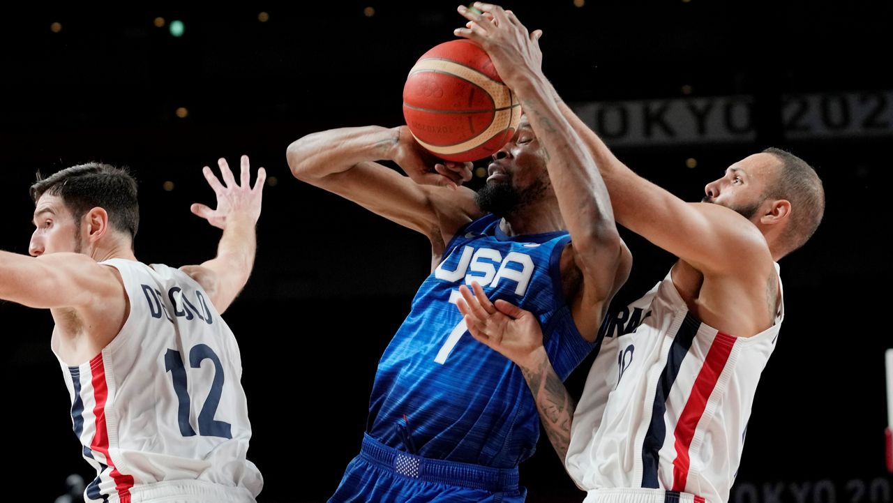 United States' forward Kevin Durant and France's Evan Fournier fight for the ball during a men's basketball preliminary round game at the 2020 Summer Olympics,. (AP/Eric Gay)