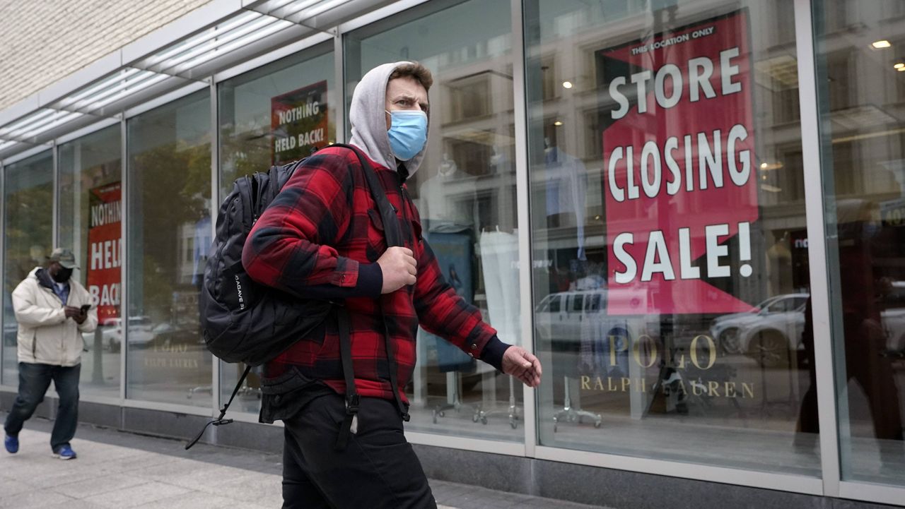 A passerby walks past a store-closing sign in the window of a department store in Boston on Tuesday. (AP Photo/Steven Senne)