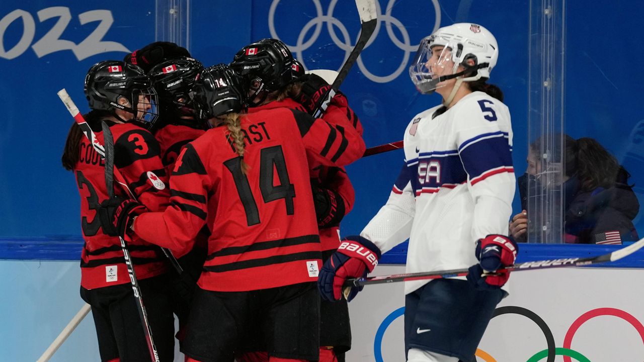 Canada celebrates a goal Thursday during the women's gold medal hockey game as the United States' Megan Keller skates by at the Winter Olympics in Beijing. (AP Photo/Petr David Josek)