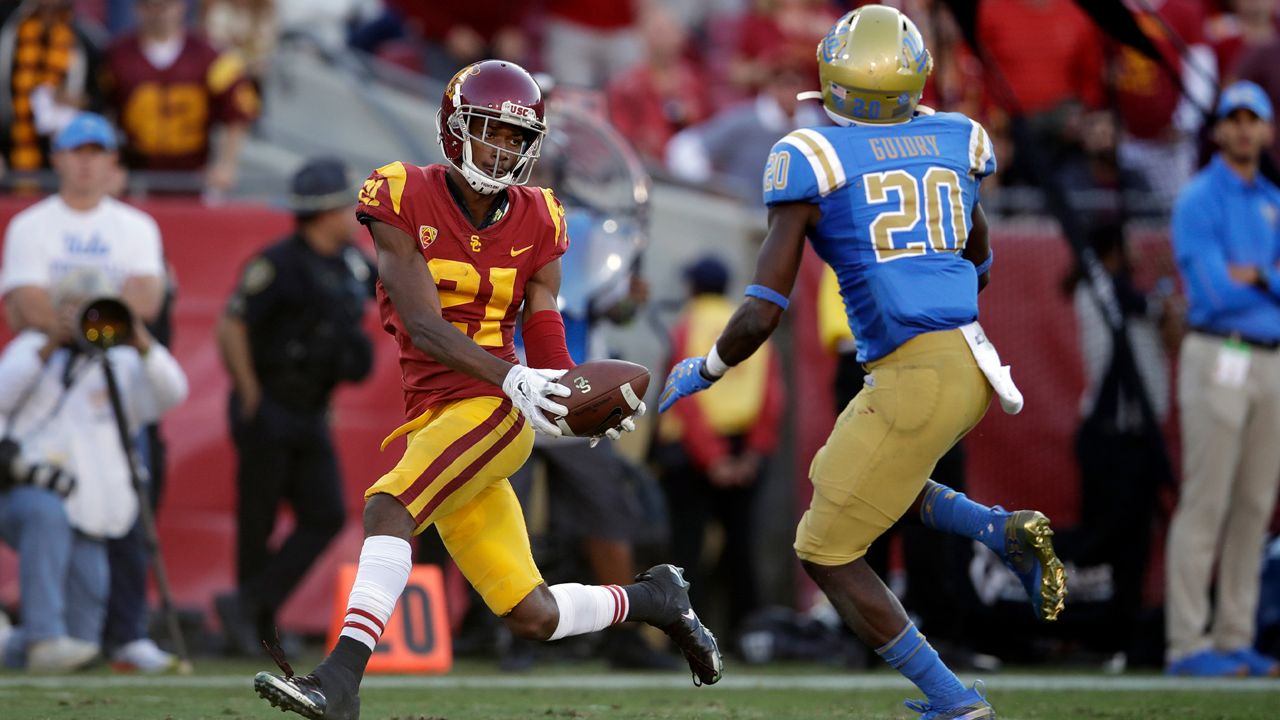 Southern California wide receiver Tyler Vaughns (21) makes a touchdown catch in front of UCLA defensive back Elisha Guidry (20) during the second half of an NCAA college football game, Saturday, Nov. 23, 2019, in Los Angeles. (AP Photo/Marcio Jose Sanchez)