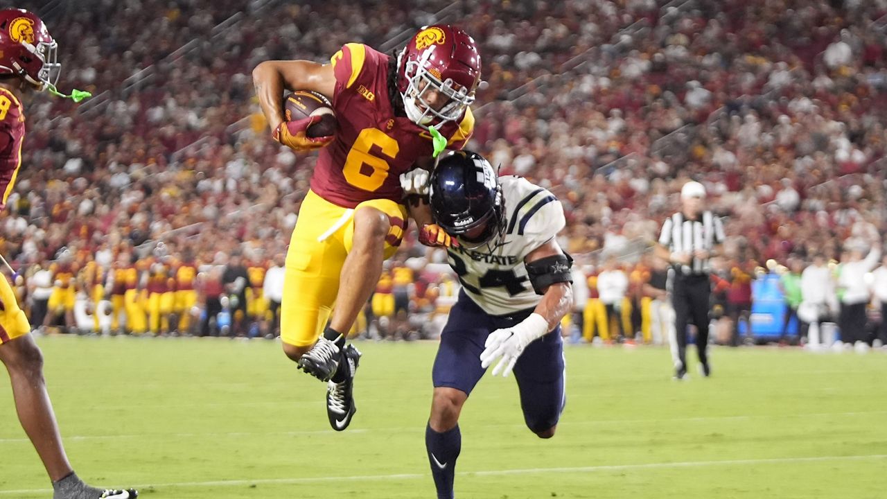 Southern California wide receiver Makai Lemon, left, jumps in for a touchdown as Utah State safety Jordan Vincent defends during the first half of an NCAA college football game, Saturday, Sept. 7, 2024, in Los Angeles. (AP Photo/Mark J. Terrill)