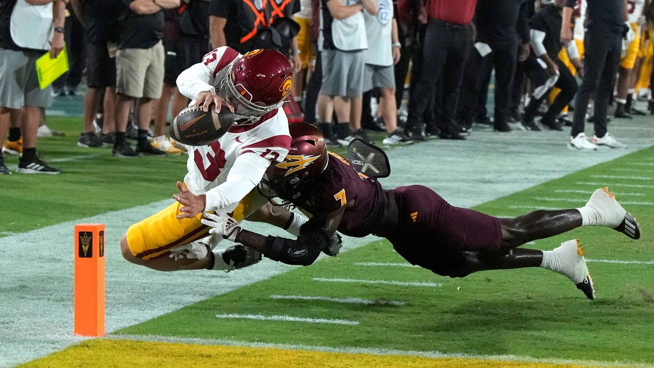 Southern California quarterback Caleb Williams (13) scores a touchdown over Arizona State defensive back Shamari Simmons during the first half of an NCAA college football game, Saturday, Sept. 23, 2023, in Tempe, Ariz. (AP Photo/Rick Scuteri)