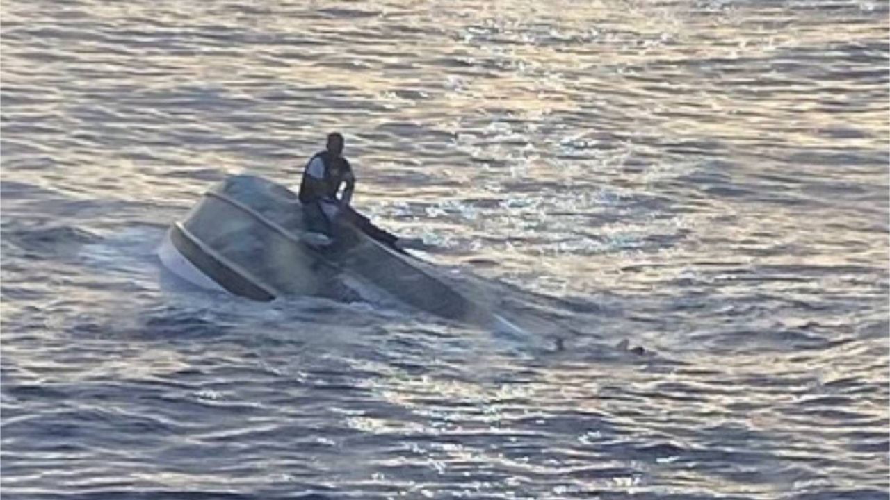 USCG rescuing man found on capsized vessel (Courtesy: USCG / U.S. Embassy Nassau)
