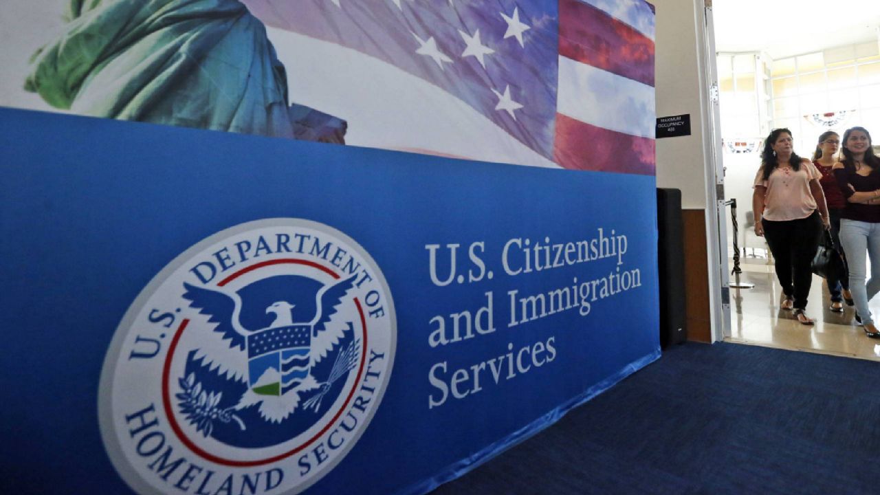 FILE - In this file photo, people arrive before the start of a naturalization ceremony at the U.S. Citizenship and Immigration Services Miami Field Office in Miami.  (AP Photo/Wilfredo Lee, File)