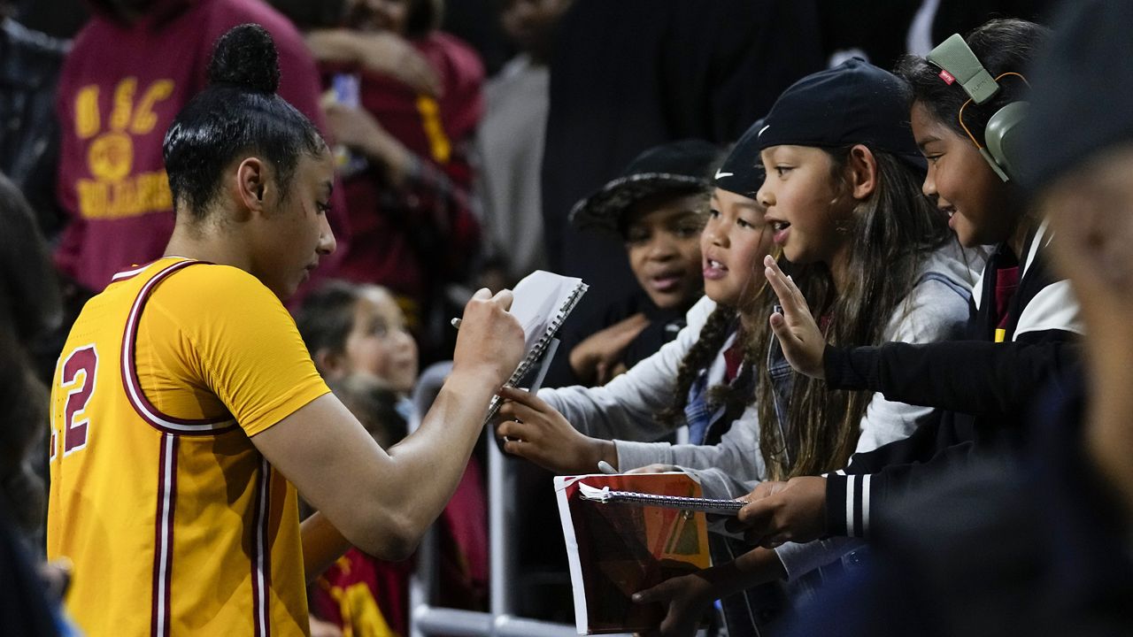 Southern California guard JuJu Watkins (12) signs autographs for fans after a 73-55 win over Kansas in a second-round college basketball game in the women's NCAA Tournament in Los Angeles, Monday, March 25, 2024. (AP Photo/Ashley Landis)