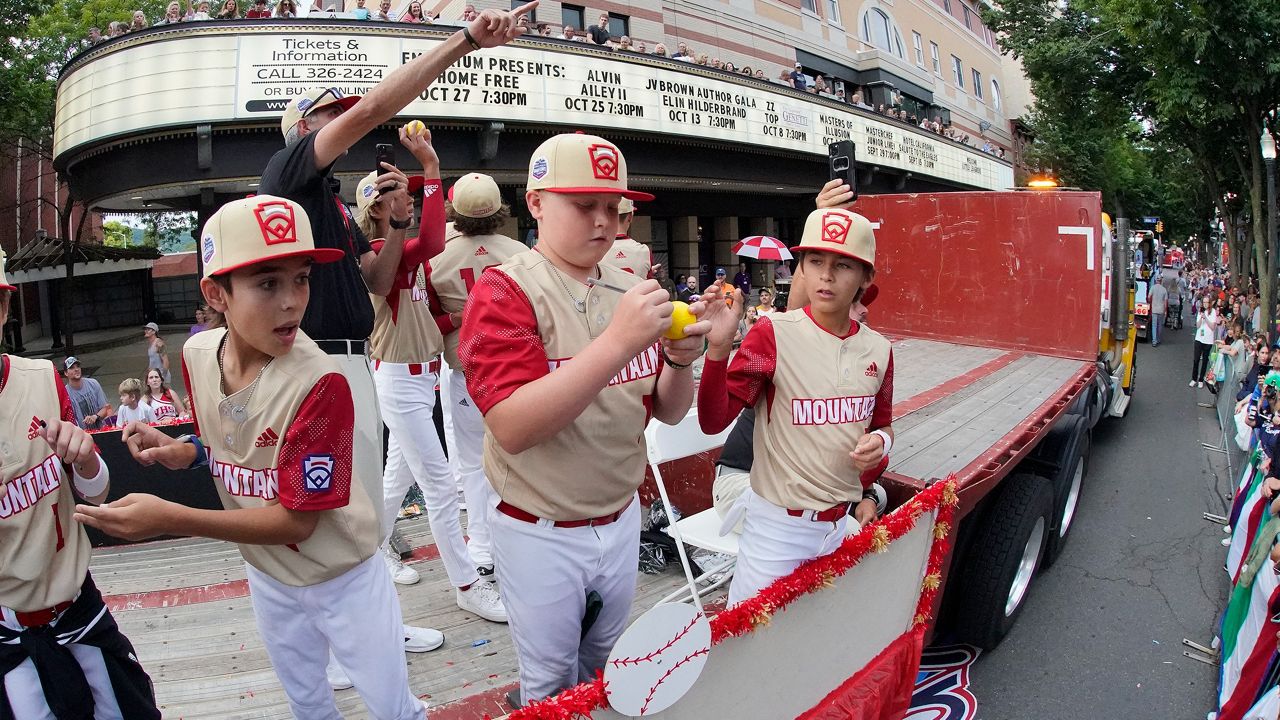 The Mountain Region champion Little League team from Santa Clara, Utah, rides in the Little League Grand Slam Parade in downtown Williamsport, Pa., Monday. One of the members of the team, Easton Oliverson, is in critical condition after falling from a bunk bed. (AP Photo/Gene J. Puskar)