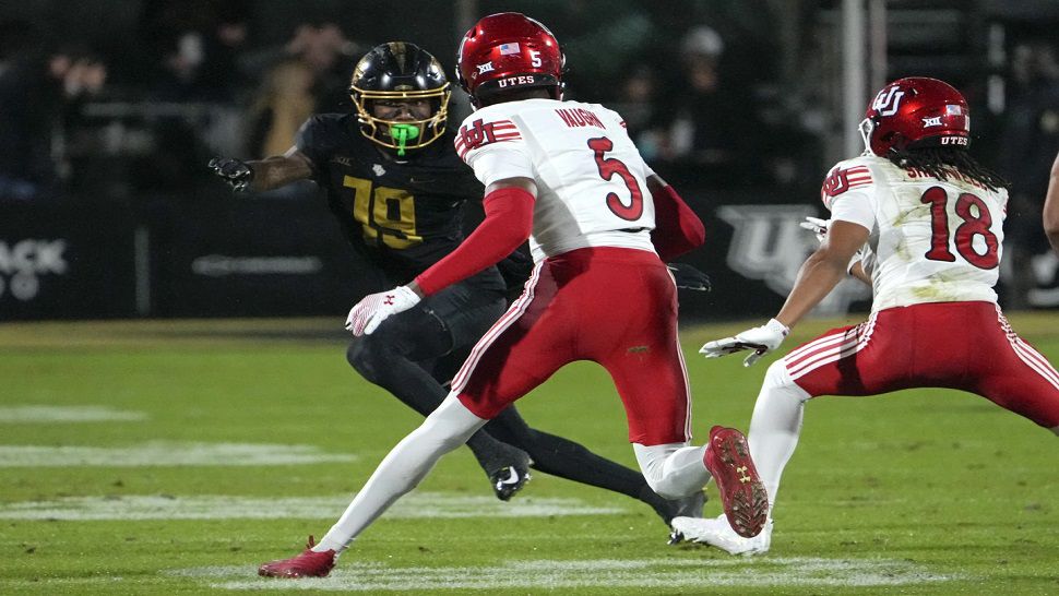 Utah cornerback Zemaiah Vaughn (5) runs back an interception for a 60-yard touchdown past Central Florida wide receiver Jarrad Baker, left, during the first half of an NCAA college football game, Friday, Nov. 29, 2024, in Orlando, Fla. (AP Photo/John Raoux)