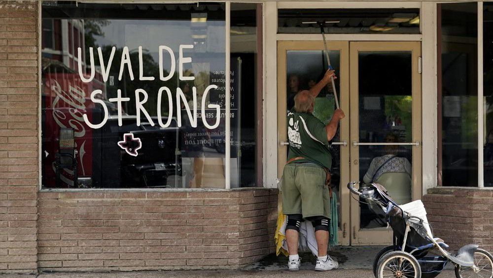 A window washer work around the town square, Thursday, June 9, 2022, in Uvalde, Texas. Uvalde is home to the Texas elementary school where a gunman killed 19 children and two teachers has long been a part of the fabric of the small city of Uvalde, a school attended by generations of families, and where the spark came that led to Hispanic parents and students to band together to fight discrimination over a half-century ago. (AP Photo/Eric Gay)