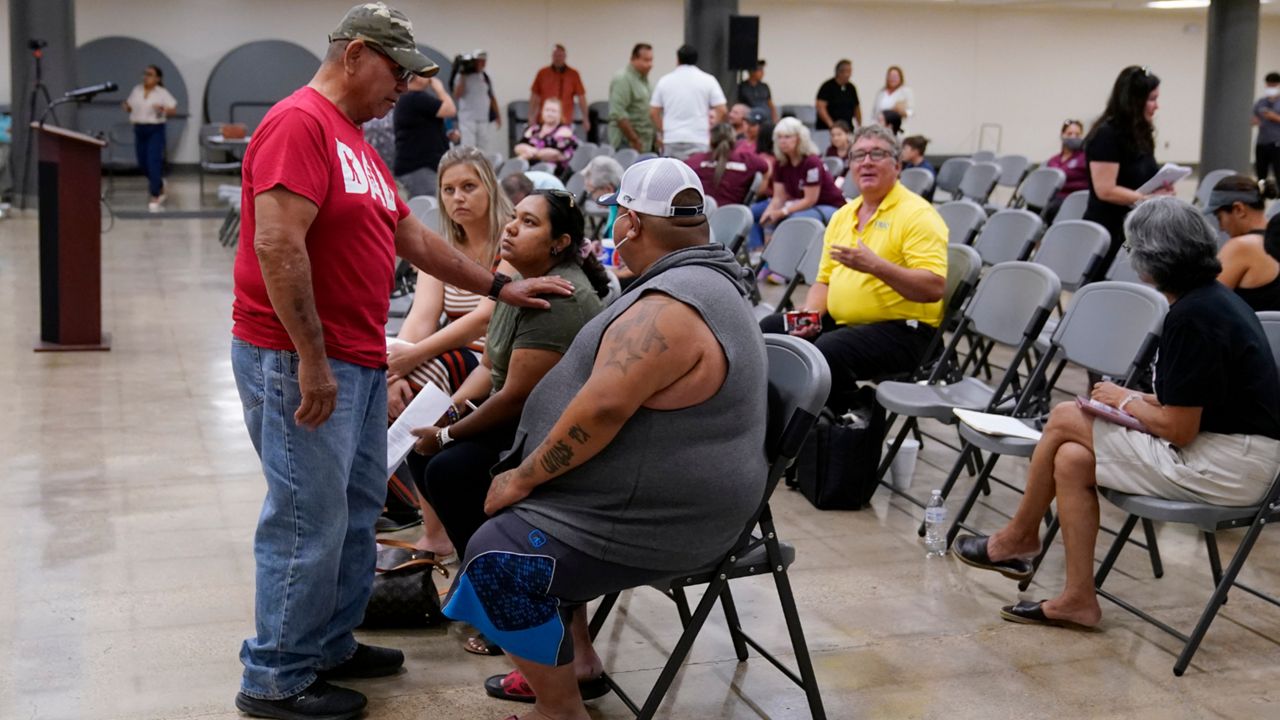 Family members of a shooting victim, who did not wish to share their names, and friends attend a city council meeting, Tuesday, July 12, 2022, in Uvalde, Texas. A Texas lawmaker says surveillance video from the school hallway at Robb Elementary School where police waited as a gunman opened fire in a fourth-grade classroom will be shown this weekend to residents of Uvalde. (AP Photo/Eric Gay)
