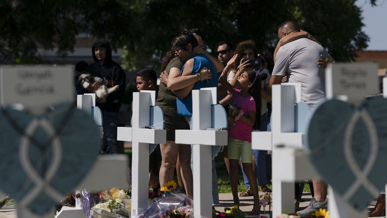 Dora Mendoza, center right, a grandmother of Amerie Jo Garza, one of the victims killed in this week's elementary school shooting, is comforted by a woman at a memorial site in Uvalde, Texas, Thursday, May 26, 2022. (AP Photo/Jae C. Hong)