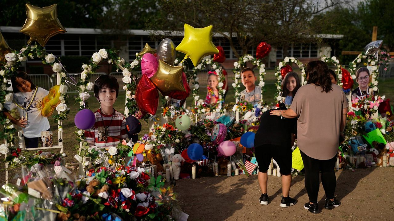 Jolean Olvedo, left, weeps May 31 while being comforted by her partner, Natalia Gutierrez, at a memorial for Robb Elementary School students and teachers killed in the May 24 mass shooting. (AP Photo/Jae C. Hong)