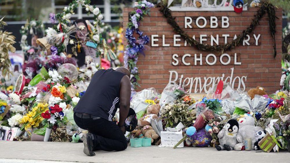 Reggie Daniels pays his respects a memorial at Robb Elementary School on June 9, 2022, in Uvalde, Texas. Nearly 400 law enforcement officials rushed to the mass shooting that left 21 people dead at the elementary school but “systemic failures” created a chaotic scene that lasted more than an hour before the gunman was finally confronted and killed, according to a report from investigators released Sunday, July 17, 2022. (AP Photo/Eric Gay, File)