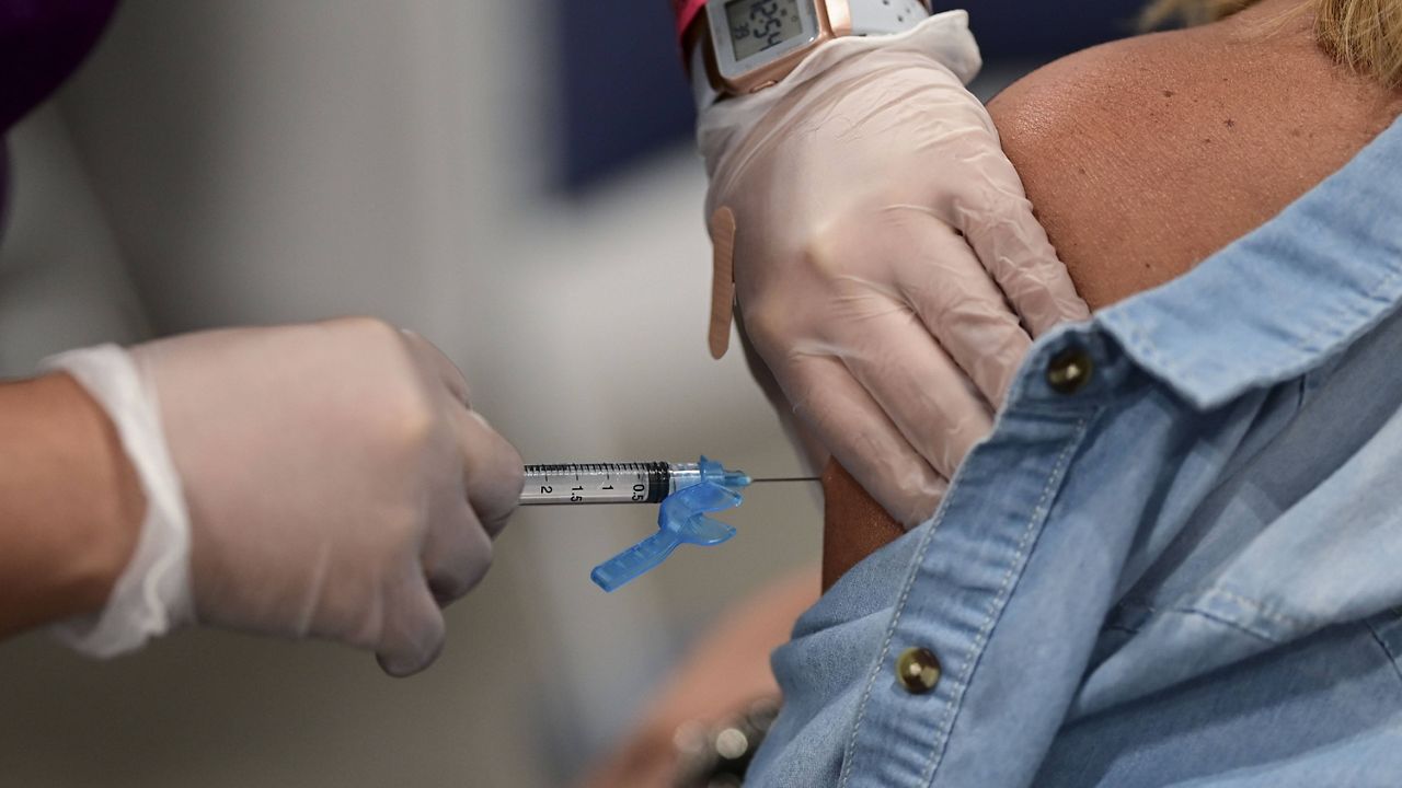 A health worker administers the Johnson & Johnson COVID-19 vaccine during a mass vaccination event in San Juan, Puerto Rico, on Wednesday. (AP Photo/Carlos Giusti)