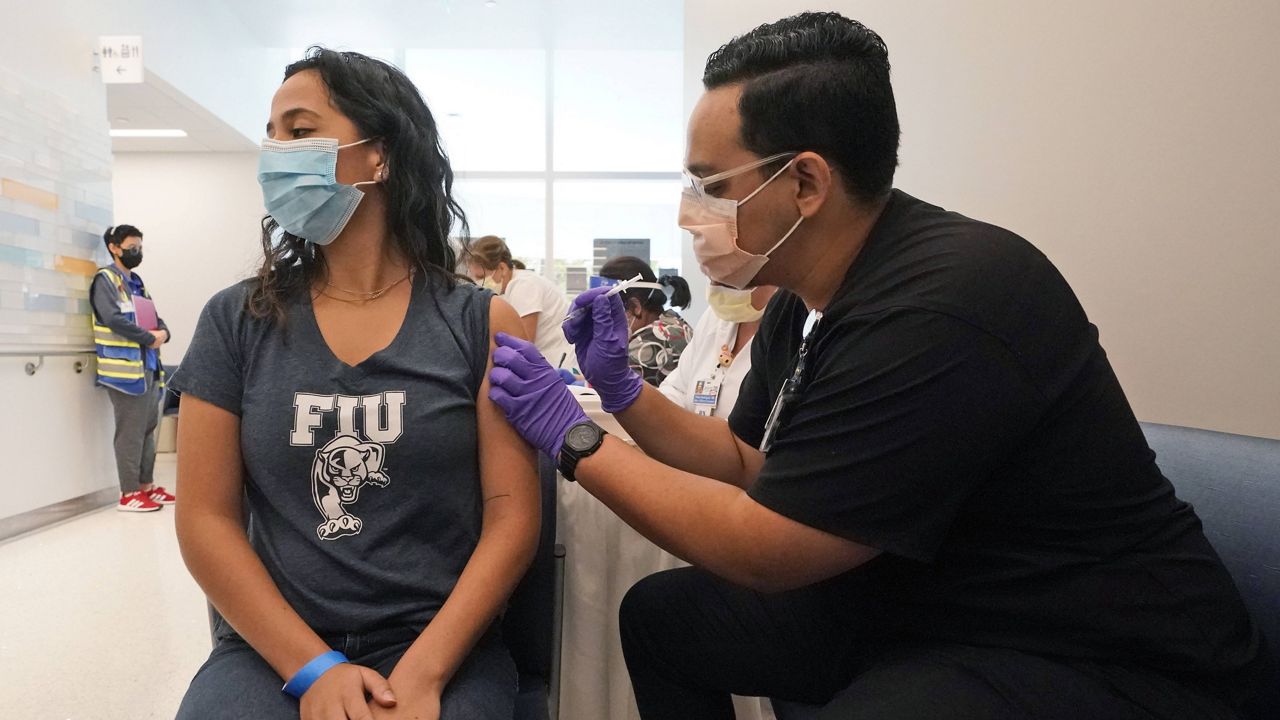 Jason Rodriguez, right, a University of Florida Pharmacy student, gives Camila Gutierrez the Pfizer COVID-19 vaccine Thursday in Miami. (AP Photo/Wilfredo Lee)