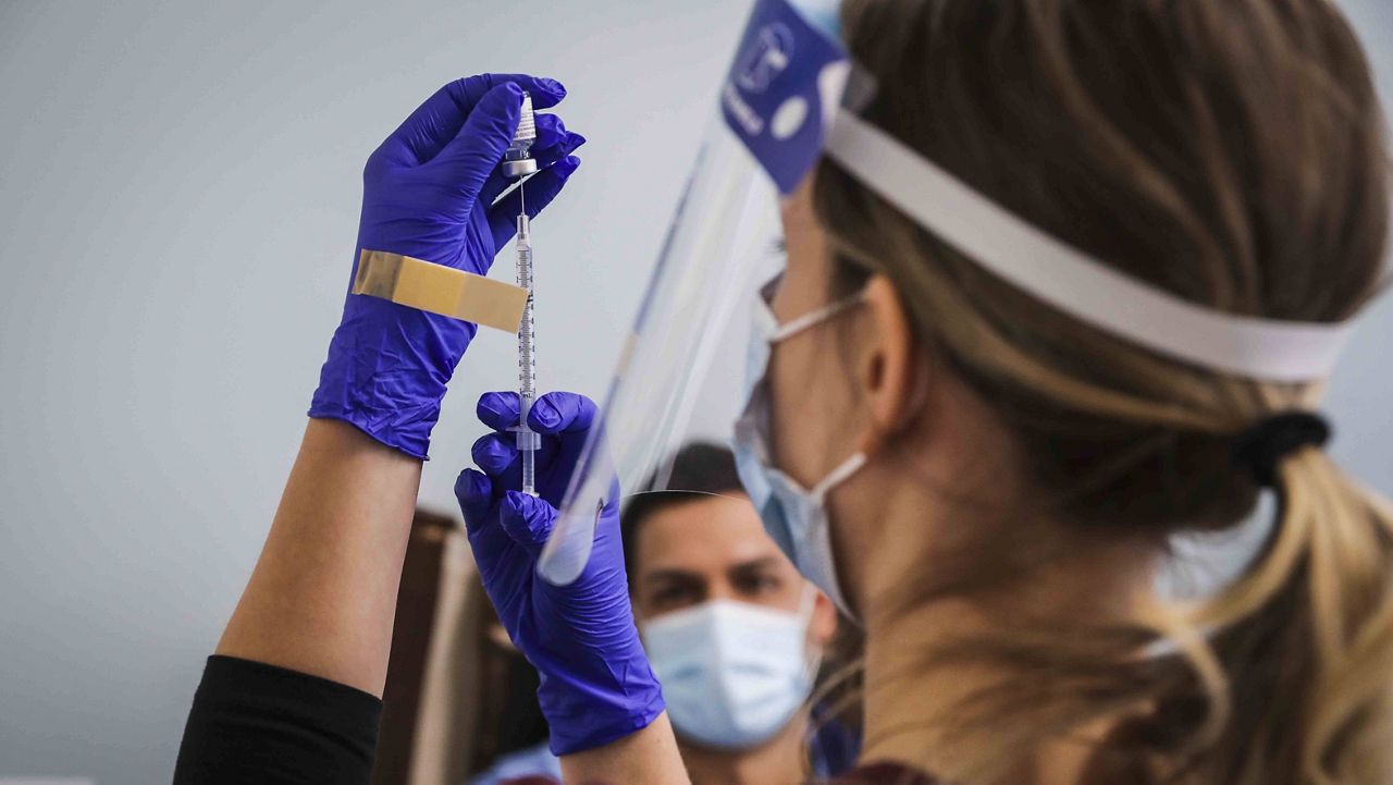Nurse Kayla Johnson prepares a Pfizer-BioNTech COVID-19 vaccine at Boston Medical Center in Boston on Dec. 16, 2020. (Erin Clark//The Boston Globe via AP, Pool)