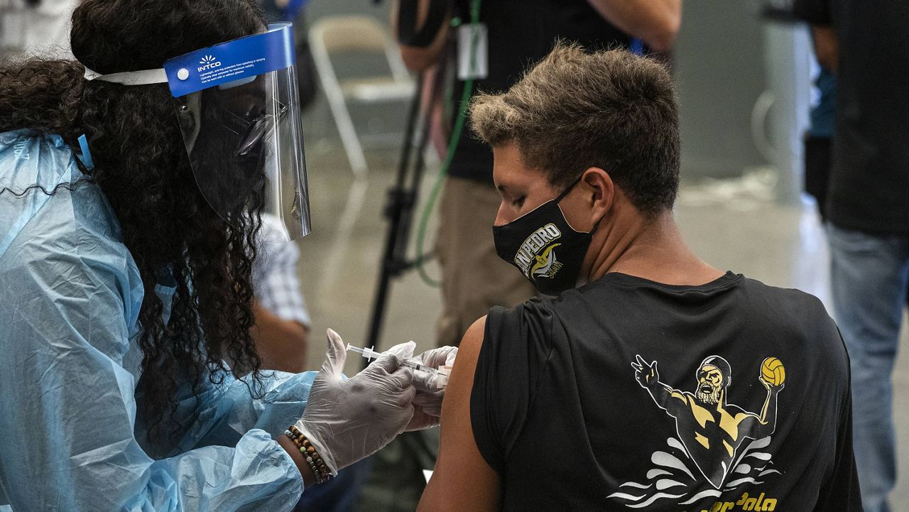 High school student William Hatch is vaccinated in San Pedro, Calif., on May 24. (AP Photo/Damian Dovarganes)