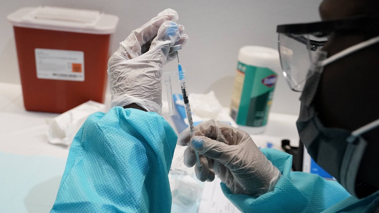 A health care worker fills a syringe with the Pfizer COVID-19 vaccine. (AP Photo/Mary Altaffer, File)
