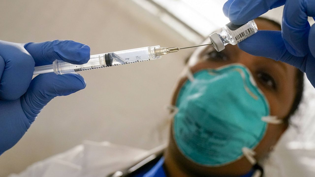 A doctor prepares a syringe with the Pfizer-BioNTech COVID-19 vaccine in New York. (AP Photo/Mary Altaffer, File)