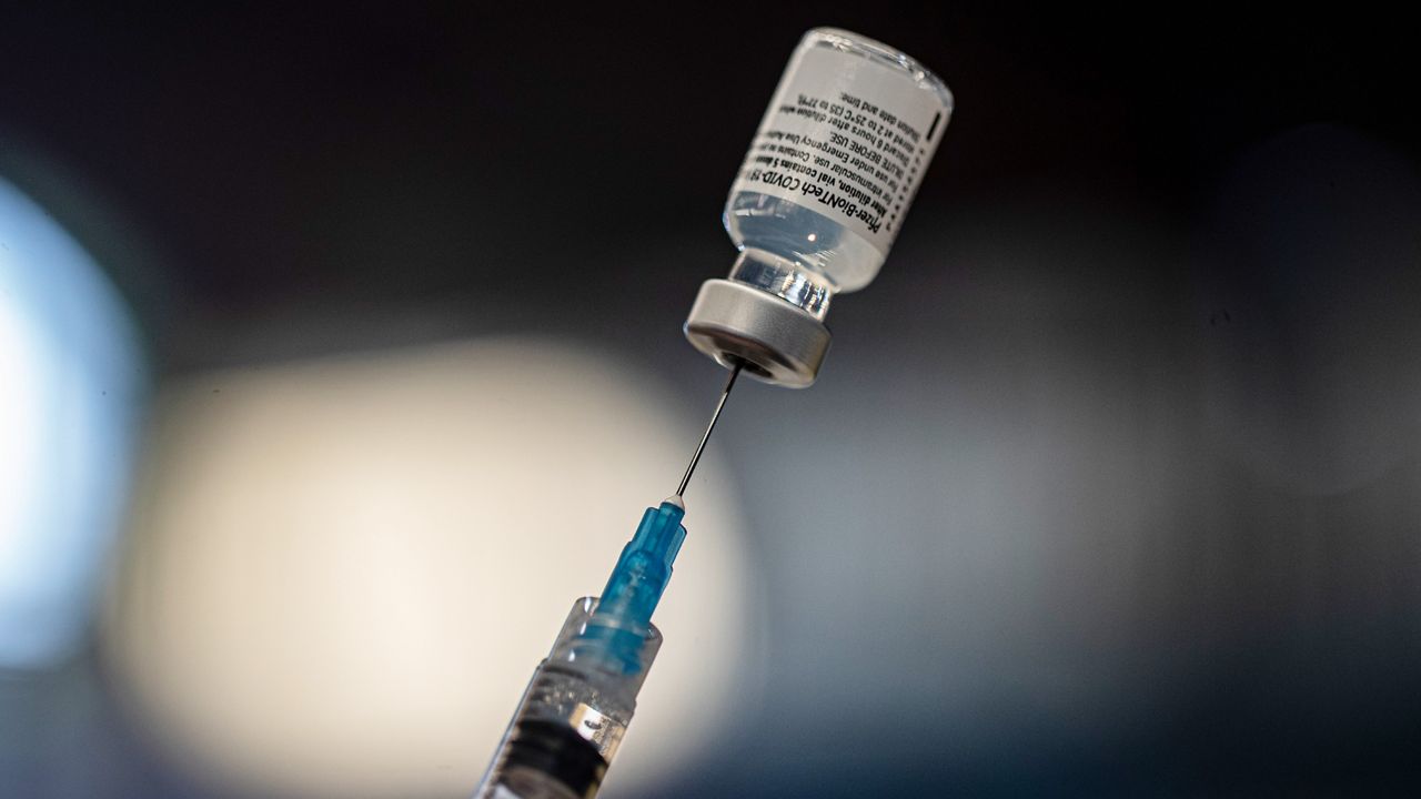 A COVID-19 vaccine is drawn into a needle. (Associated Press)