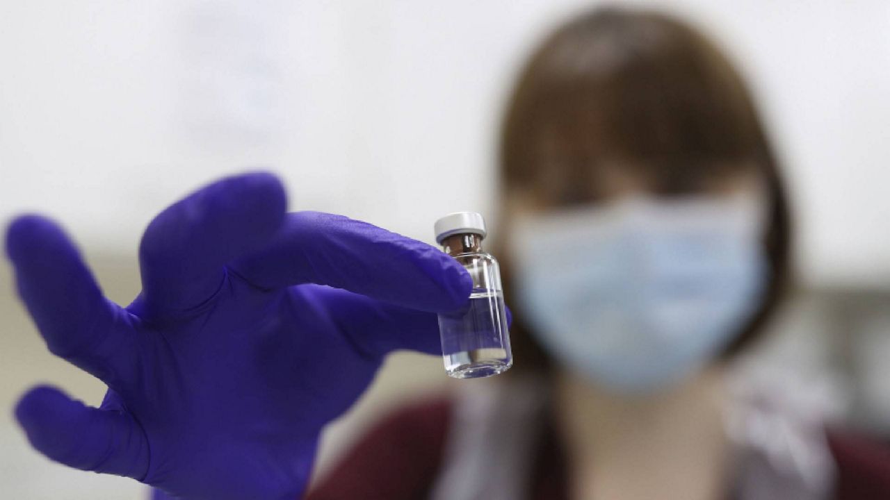 A pharmacy technician simulates the preparation of the Pfizer vaccine in London. (Yui Mok/Pool Photo via AP)