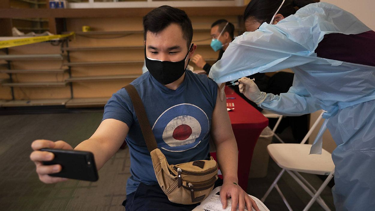 FILE - In this April 12, 2021, file photo, Freeson Wong, 31, takes a selfie as he receives a dose of the Moderna vaccine at a vaccination center in the Chinatown neighborhood of Los Angeles. (AP Photo/Jae C. Hong, File)
