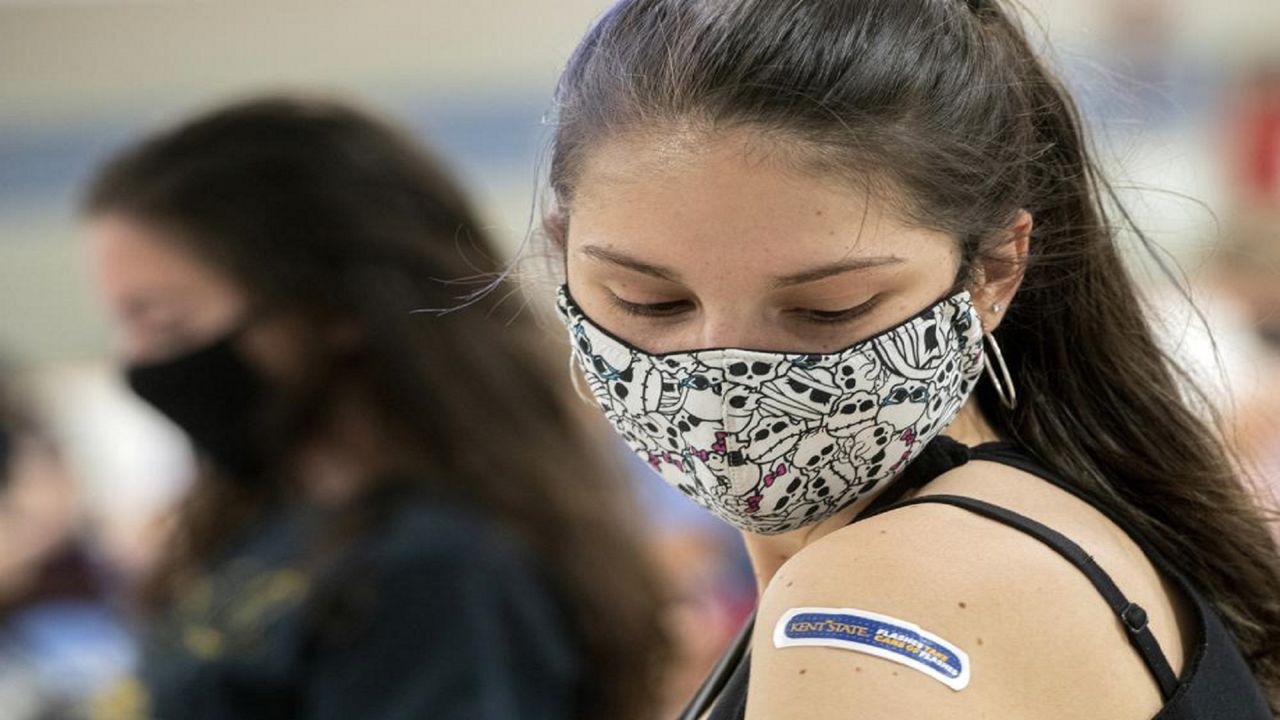 FILE - In this Thursday, April 8, 2021, file photo, Kent State University student Regan Raeth, of Hudson, Ohio, looks at her vaccination bandage as she waits for 15 minutes after her shot in Kent, Ohio. 