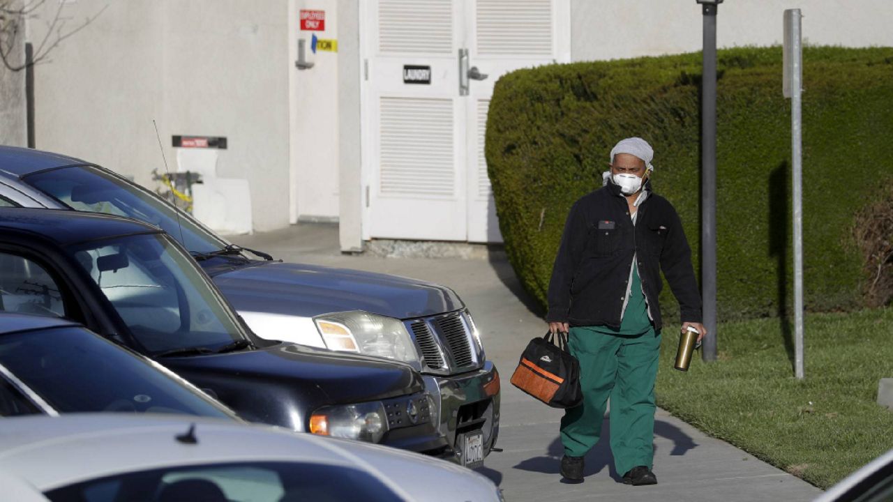 FILE - In this file photo a health care worker leaves Cedar Mountain Post Acute nursing facility in California. (AP Photo/Chris Carlson, File)