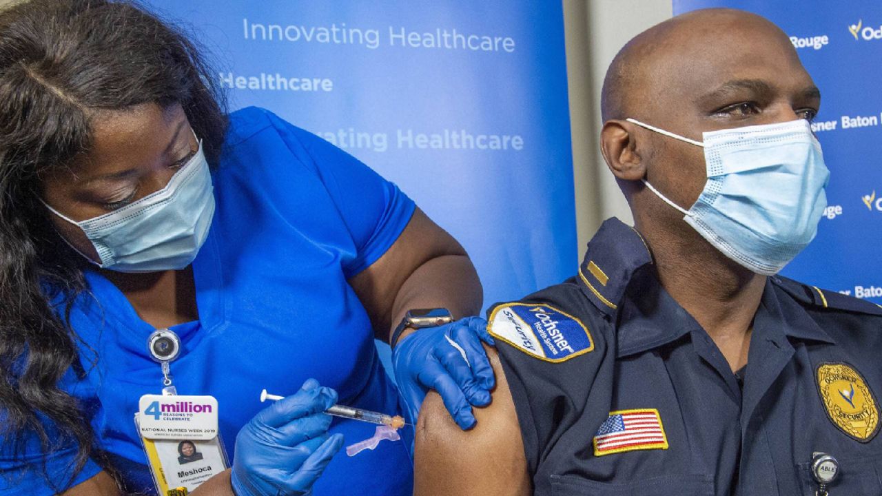 A hospital security guard is inoculated with the Pfizer-BioNTech COVID-19 vaccine on Tuesday in Louisiana. (Bill Feig/The Advocate via AP, Pool)