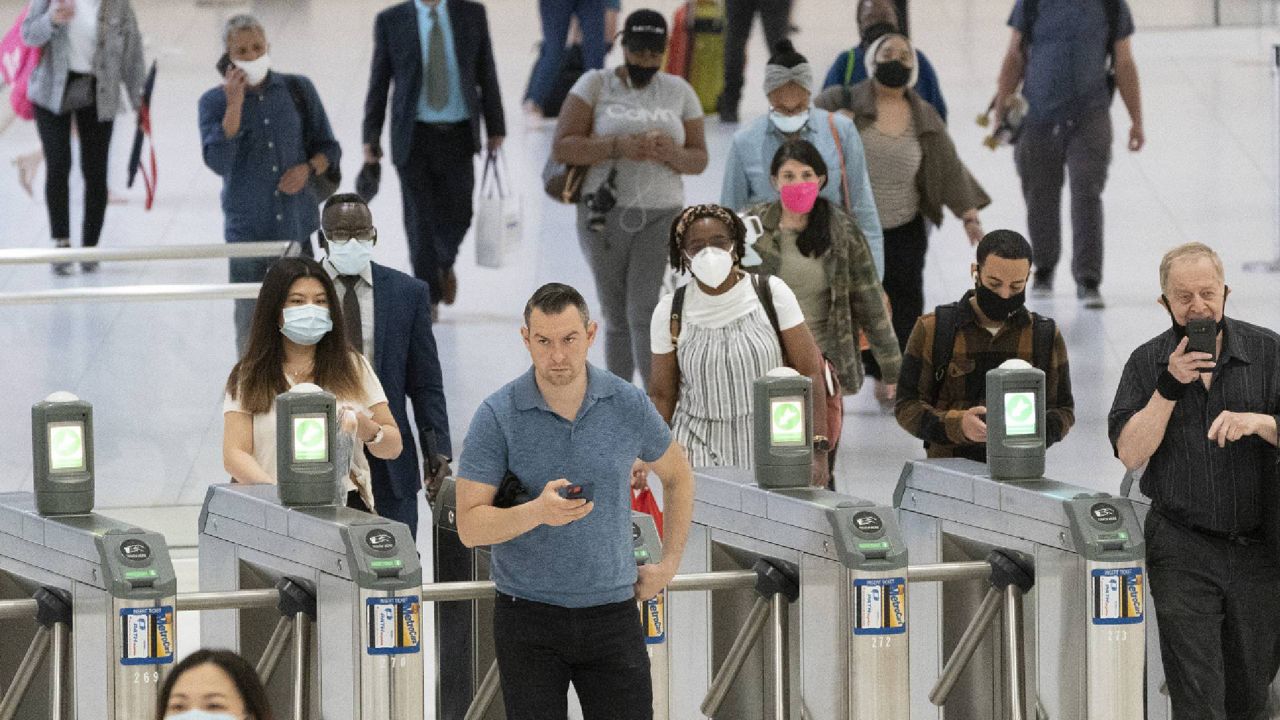 FILE - People commute through the World Trade Center, Friday, July 9, 2021, in New York. Businesses that have announced vaccine mandates say some workers who had been on the fence have since gotten inoculated against COVID-19. But many holdouts remain, a likely sign of what is to come once a federal mandate goes into effect. (AP Photo/Mark Lennihan)