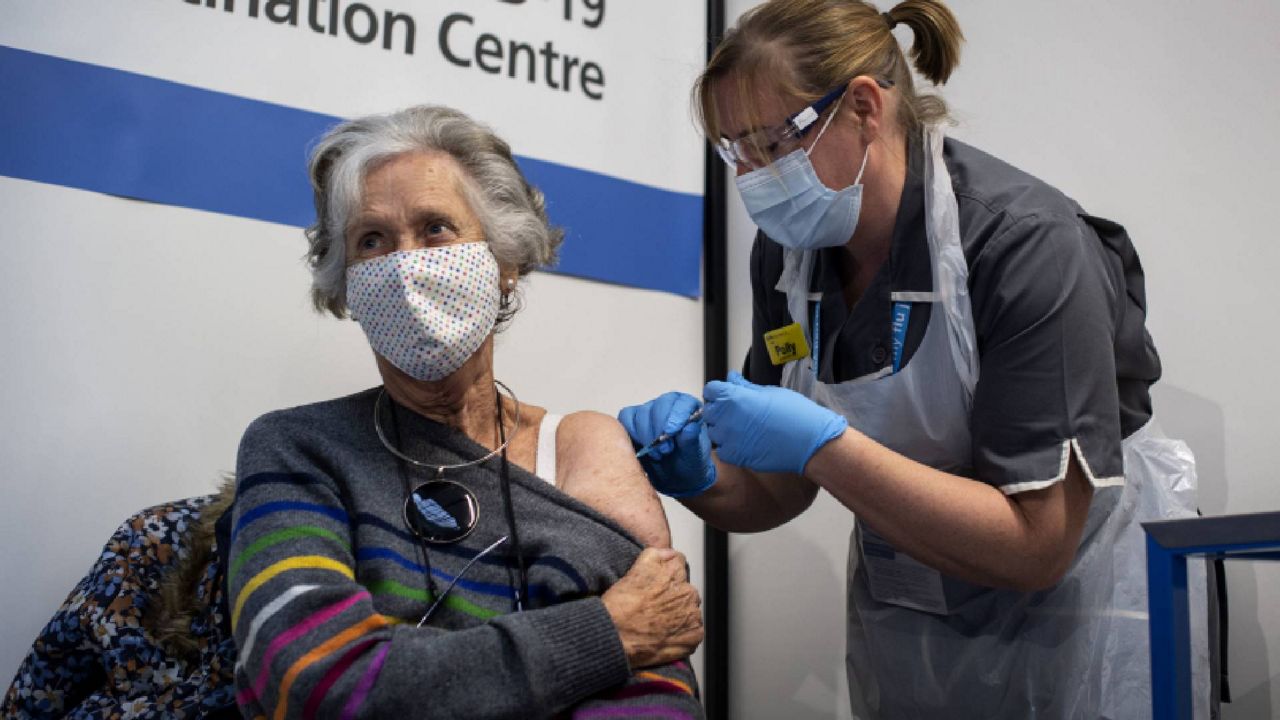 Dr. Doreen Brown, 85, receives the first of two Pfizer/BioNTech COVID-19 vaccine jabs administered at a London hospital Tuesday. (Victoria Jones/Pool via AP)