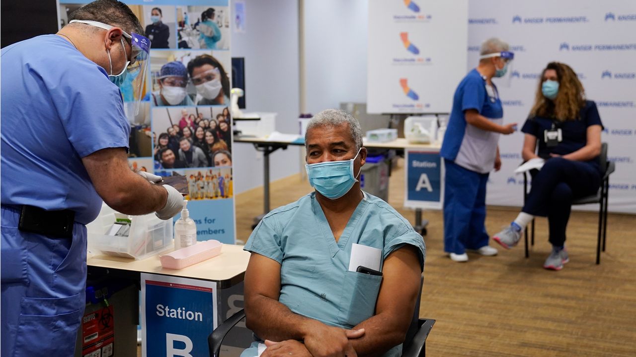 Dr. Brian Thompson waits to receive the Pfizer-BioNTech COVID-19 vaccine at Kaiser Permanente Los Angeles Medical Center in Los Angeles, Monday, Dec. 14, 2020. (AP Photo/Jae C. Hong)