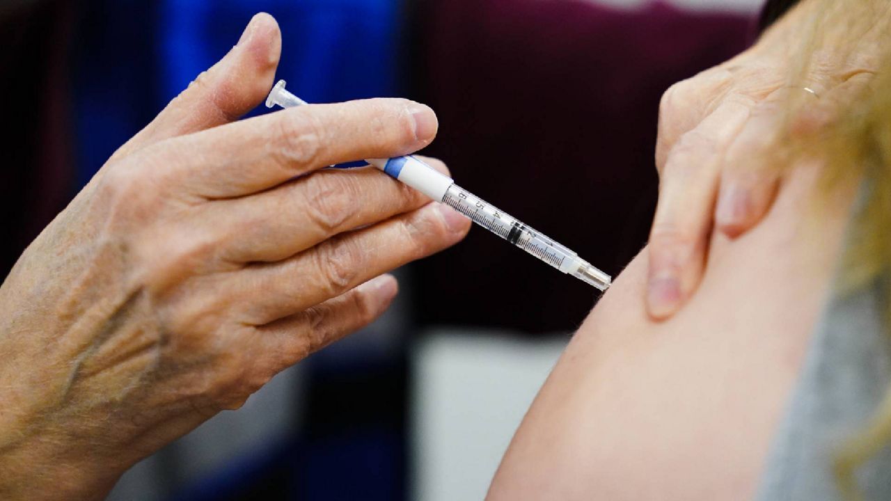 FILE - A health worker administers a dose of a COVID-19 vaccine. (AP Photo/Matt Rourke, File)