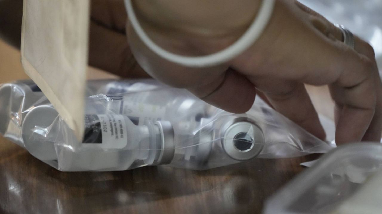 A health worker seals a bag of used Pfizer COVID-19 vials, at the city hall in Quezon city, Philippines on Monday, June 21, 2021. (AP Photo/Aaron Favila)