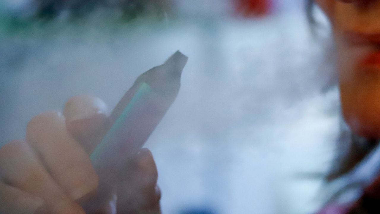 A woman uses a vaping device. (AP Photo/Keith Srakocic, File)