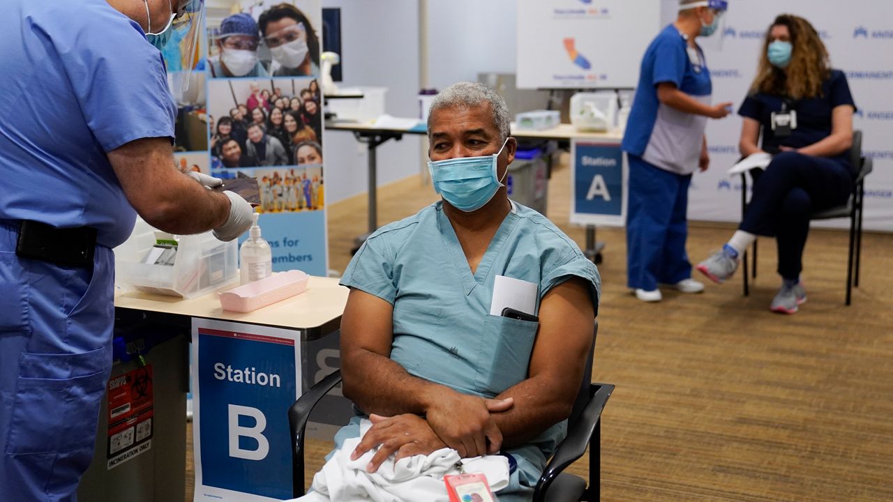 Dr. Brian Thompson waits to receive the Pfizer-BioNTech COVID-19 vaccine at Kaiser Permanente Los Angeles Medical Center in Los Angeles, Monday, Dec. 14, 2020. (AP Photo/Jae C. Hong)