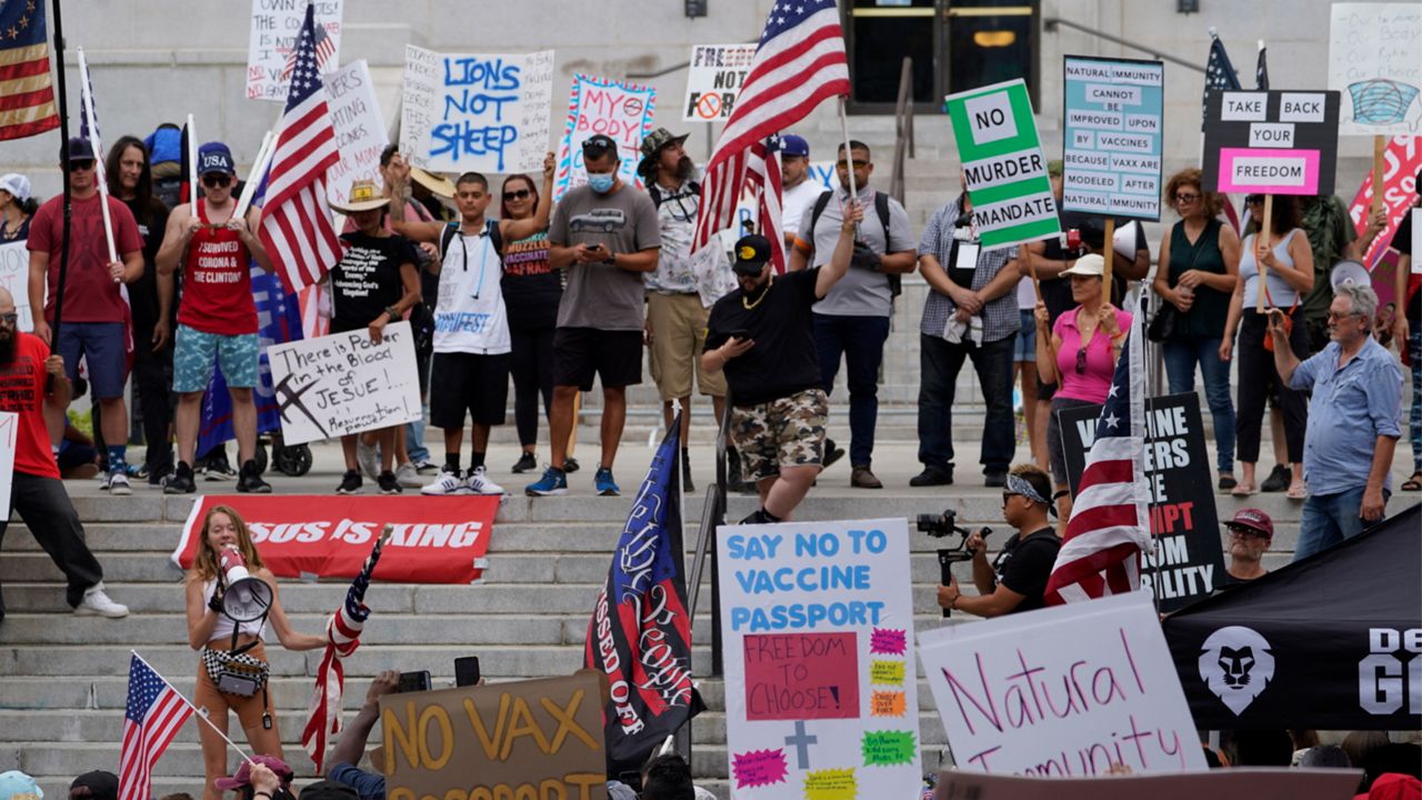 Anti vax protesters holding American flags and signs calling for "medical freedom" rally outside the City Hall in Los Angeles on Saturday, Aug. 14, 2021. (AP Photo/Damian Dovarganes)