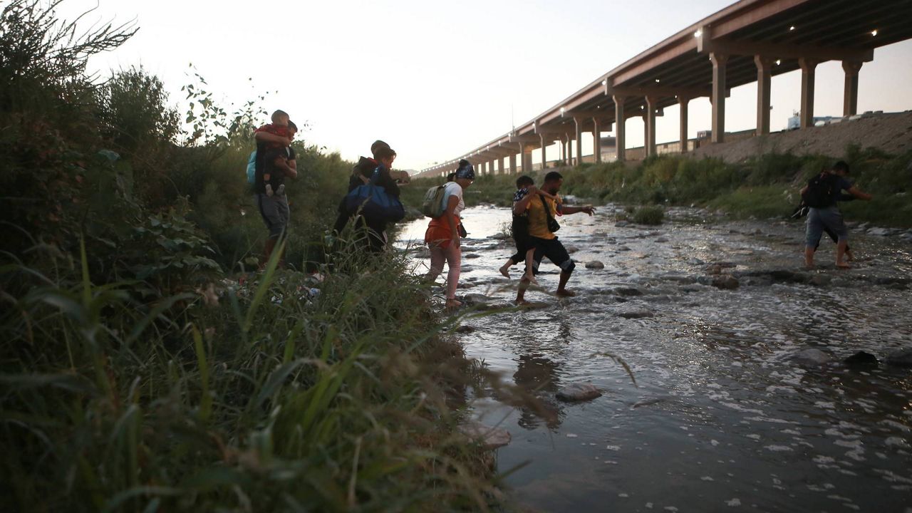 Venezuelan migrants walk across the Rio Bravo towards the United States border to surrender to the border patrol, from Ciudad Juarez, Mexico, Oct. 13, 2022. (AP Photo/Christian Chavez)