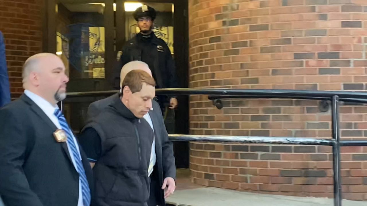 Sean Kuilan, the suspect in a series of attacks on a Manhattan gay bar, is walked out of the NYPD's 7th Precinct Tuesday afternoon after being arrested. (NY1/Victoria Manna)