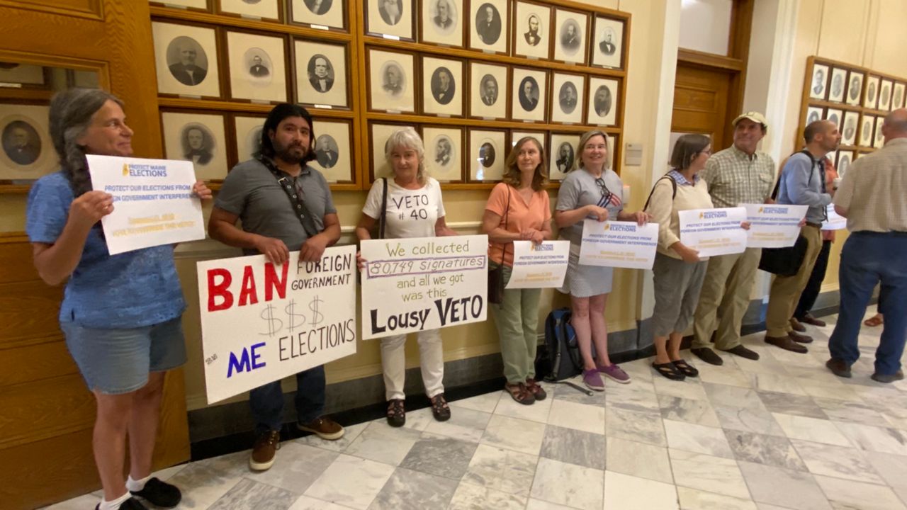 Supporters of the ban on foreign government spending work the State House halls Tuesday prior to the veto override vote. (Spectrum News/Susan Cover)