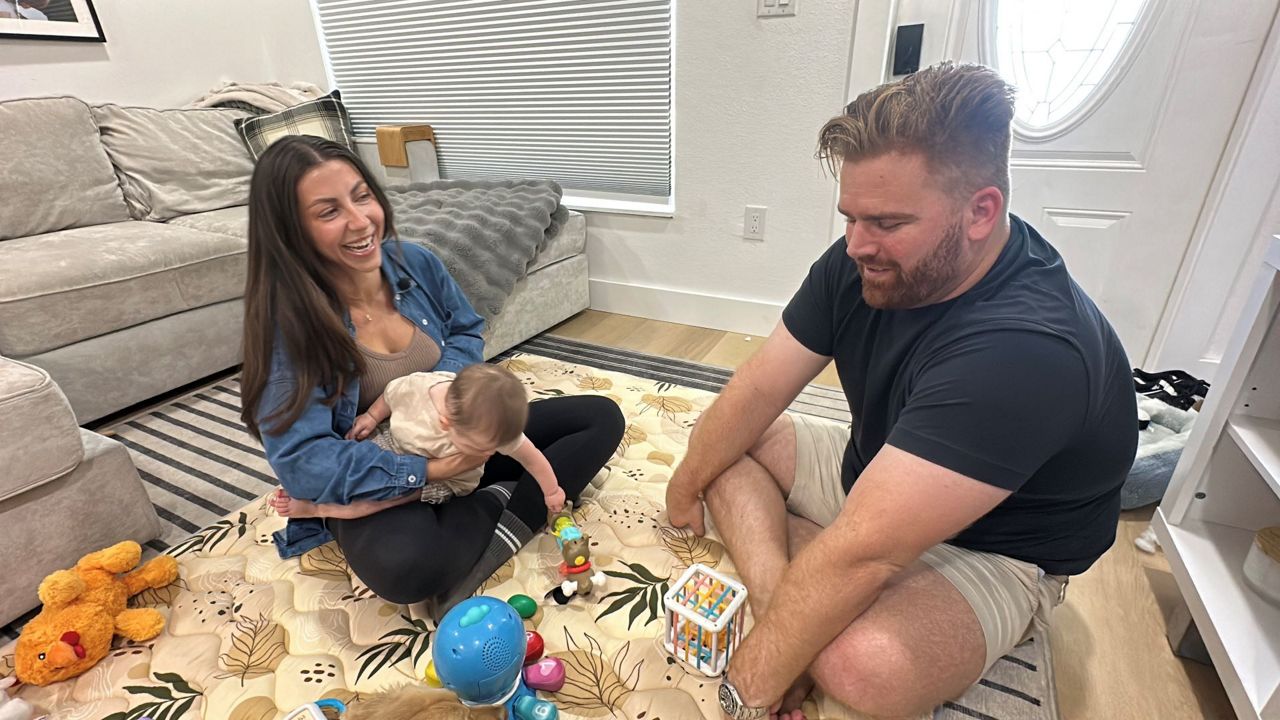 Victoria (far left), baby Callahan and Jordan Hearin were just able to move back in their home in March, which needed repairs after significant damage from hurricanes Helene and Milton last year. (Spectrum News/Randy Levine)