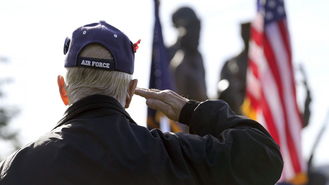 A Vietnam War veteran salutes the American flag. New York's scholarship for veterans currently applies to servicemembers who experienced active combat. Lawmakers and veterans want Gov. Kathy Hochul to sign a bill that would allow all vets to apply. (AP Photo/Steven Senne)