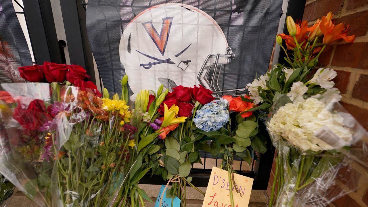 Memorial flowers and notes line a walkway at Scott Stadium on Tuesday, Nov. 15, 2022, after three football players were killed in a shooting on the grounds of the University of Virginia in Charlottesville. Va. (AP Photo/Steve Helber)