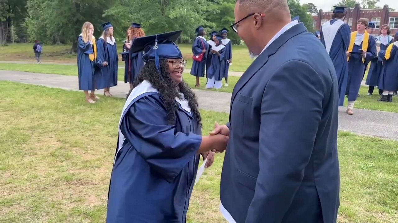 Jordan Level stands next to her father Joseph Level after receiving her high school diploma