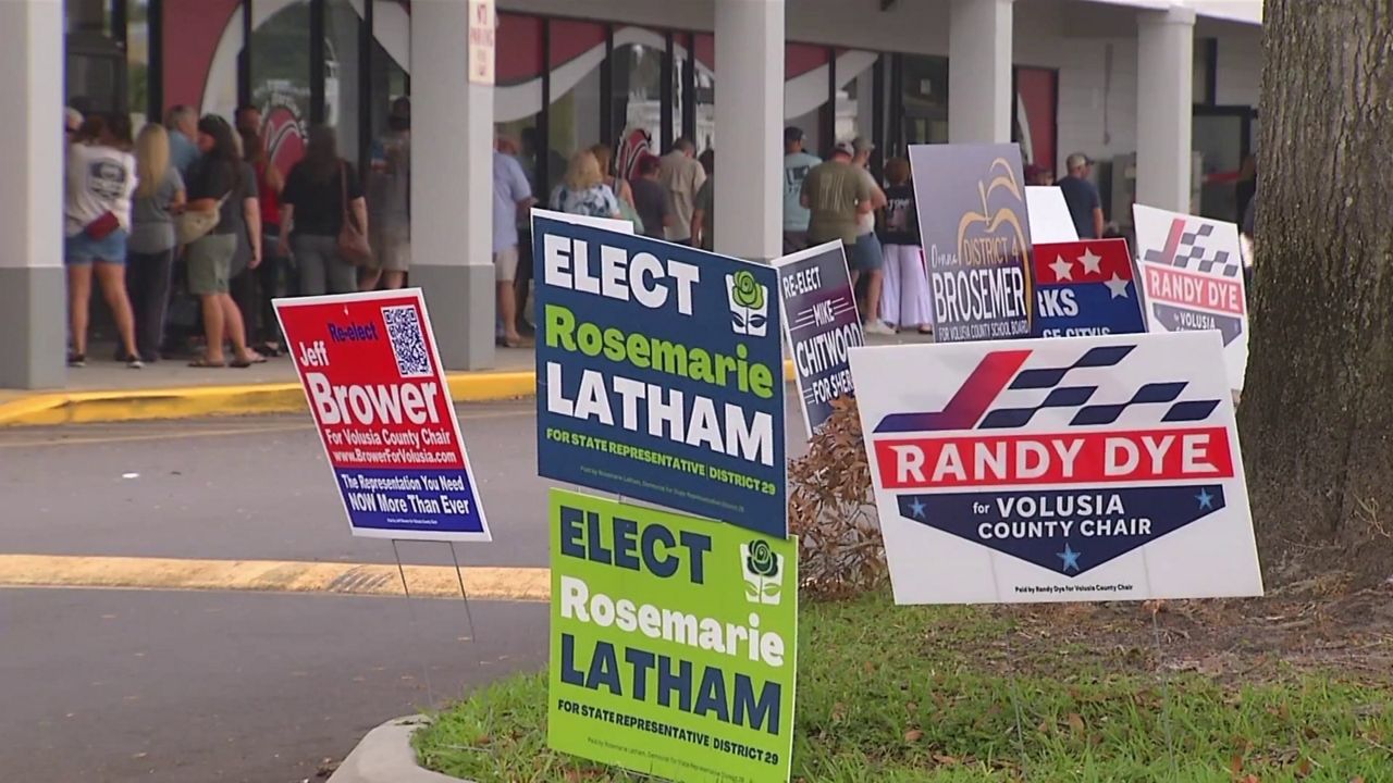 Signs promoting Volusia County candidates sit outside the Supervisor of Elections early voting site. (Spectrum News)