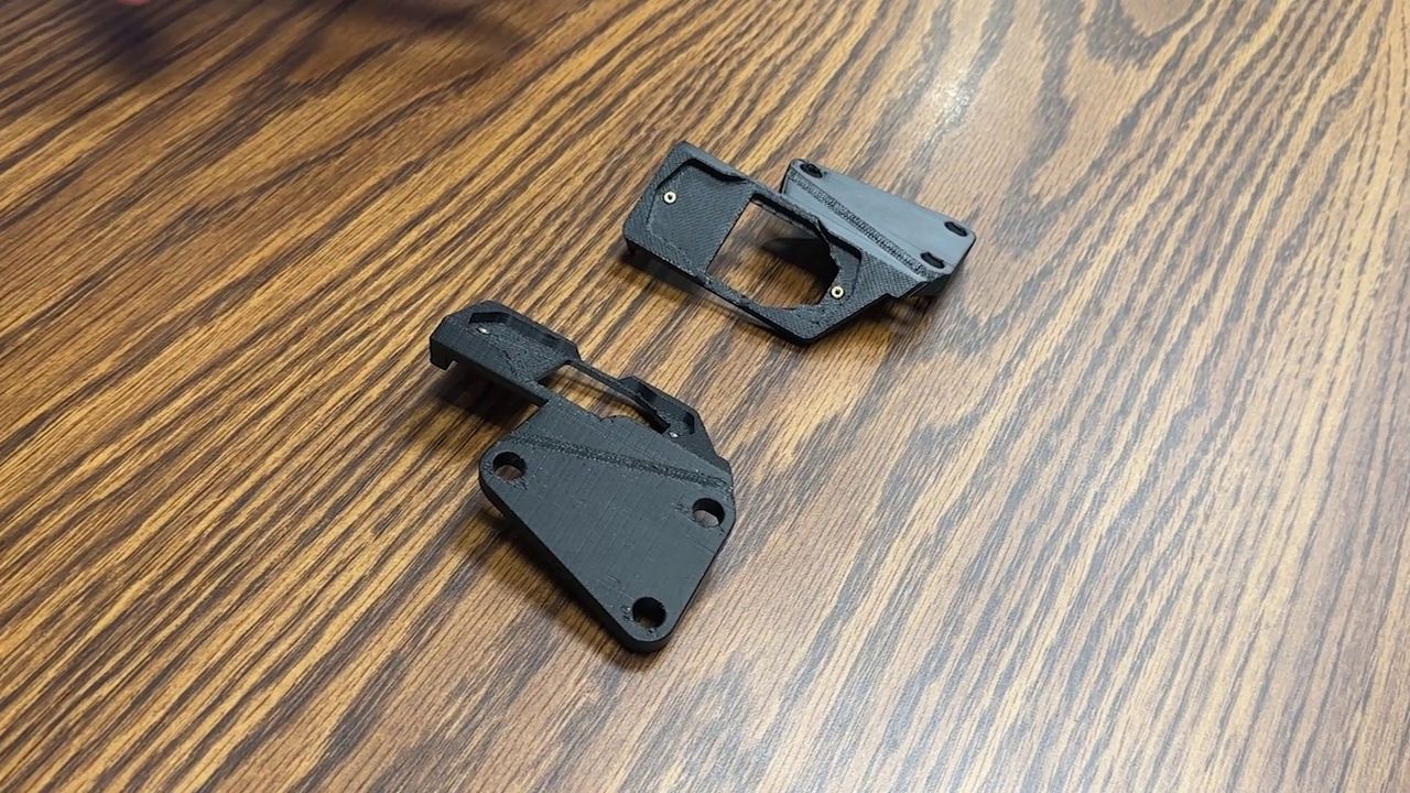 A carbon-fiber mount holds a sensor that detects when a firearm’s metal is no longer present in the holster. (Spectrum News)