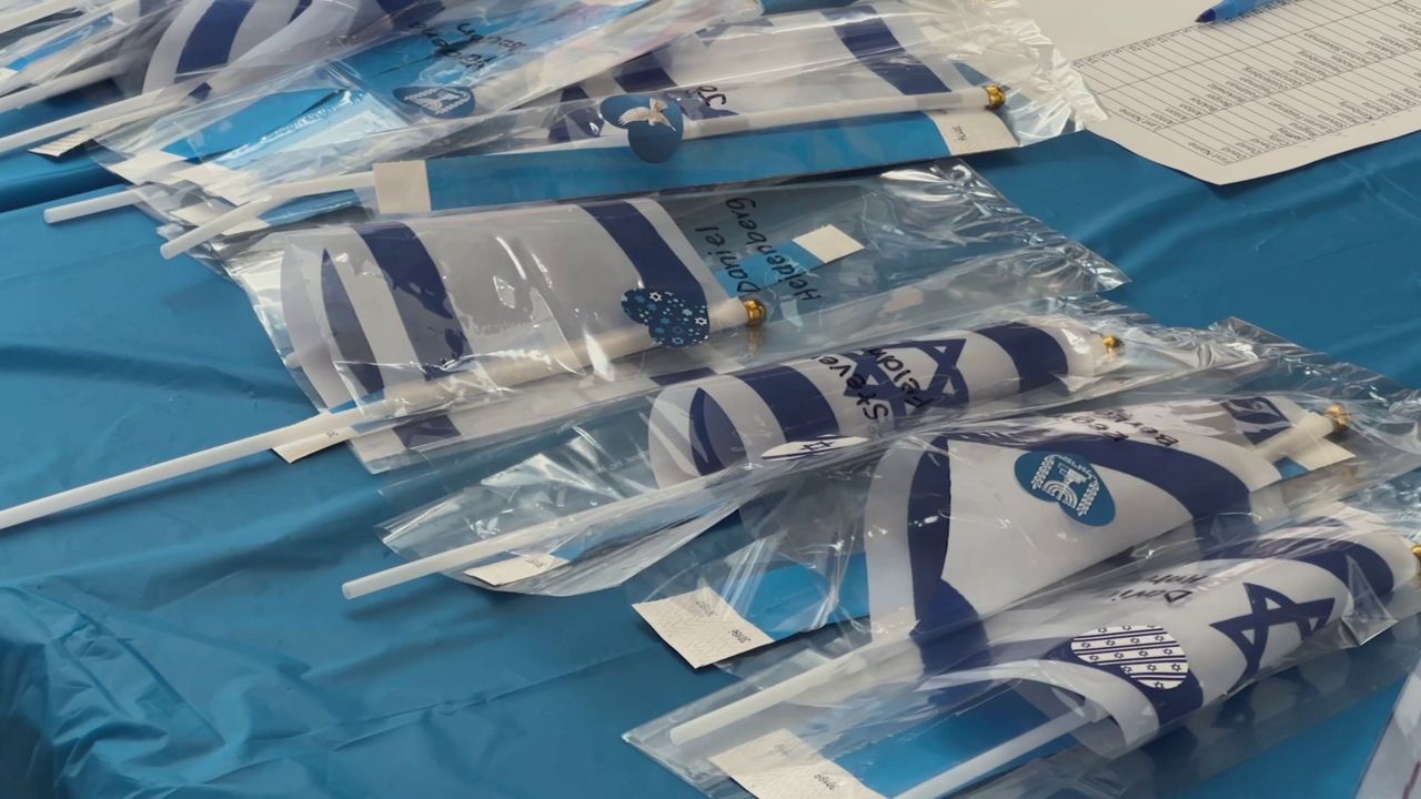 Israeli flags line a table at the Shanna and Bryan Glazer Jewish Community Center in Tampa. (Spectrum News)