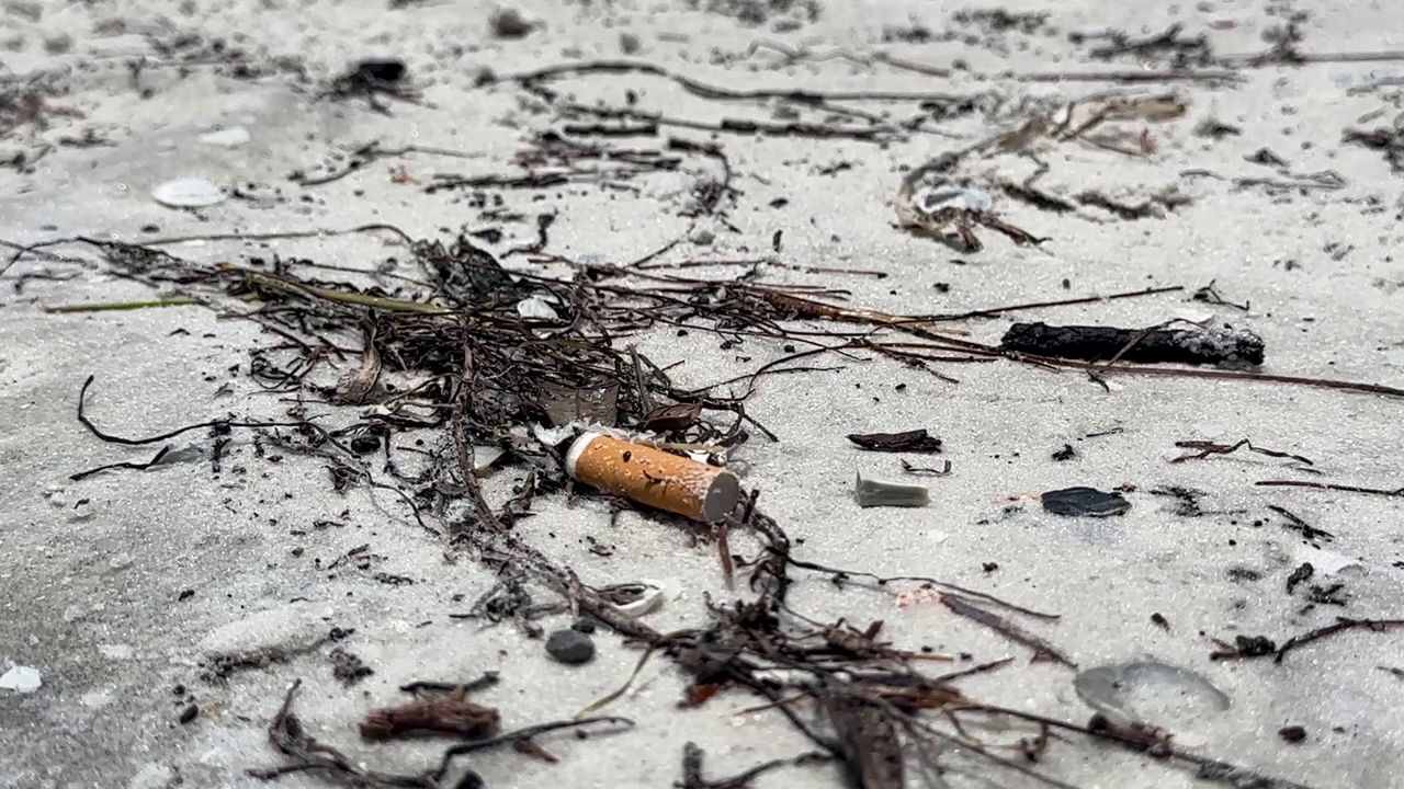 A cigarette butt lays in the sand at a beach in Gulfport, Fla. (Spectrum News/Randy Levine)