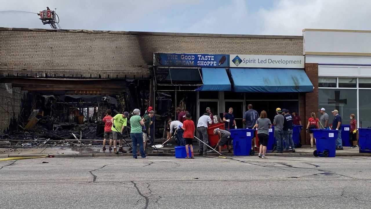 Volunteers clean up debris left from riots that destroyed dozens of local businesses in Kenosha, Wis., late Monday night. (Photo by Sabra Ayres/Spectrum News)