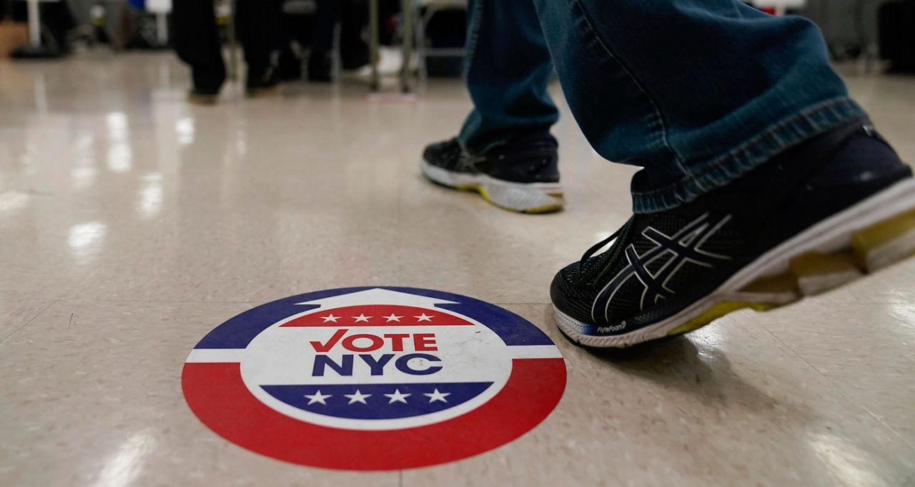 Stickers on the floor help direct voters at a polling place in New York, Tuesday, Nov. 2, 2021. (AP Photo/Seth Wenig)